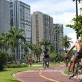 Ciclistas pedalam em ciclovia na Ponta da Praia. #pracegover