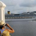 Homem de costa, com chapéu, observa a passagem de navio de cruzeiros pelo estuário de Santos. #paratodosverem