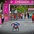 atleta na cadeira de rodas se aproxima da chegada na prova #paratodosverem
