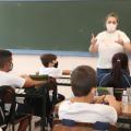 Professora na frente e alunos sentados assistindo a aula #paratodosverem