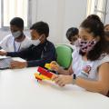 Alunos participam de aula de informática e robótica. #paratodosverem