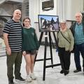 pessoas posam ao lado de fotografia #paratodosverem