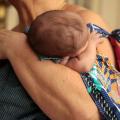 Bebê nos braços de uma mulher #paratodosverem