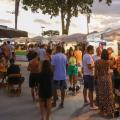 pessoas circulam em praça onde estão montadas barracas com exposição de peças artesanais. #paratodosverem
