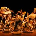 bailarinos dança em palco. Eles movimentam suas saias com velocidade. #paratodosverem 