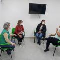 Quatro mulher conversam em uma sala sentadas em cadeiras. #paratodosverem