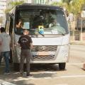 micro-ônibus está parado em avenida e três fiscais estão à frente. Eles são da Seectur, Artesp e CET-Santos 