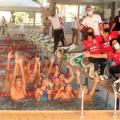 pessoas dentro de uma piscina com as mãos para cima , fora da piscina pessoas com braços abertos #paratodosverem