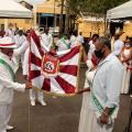 3 pessoas seguram estandarte de escola de samba #paratodosverem