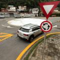 placas em primeiro plano e carro entrando na rotatória ao fundo #paratodosverem