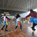 pessoas com roupas juninas dançam em roda. #paratodosverem