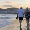 idosos andando na praia #paratodosverem