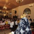 Igreja lotada de fiéis coma imagem da Santa em primeiro plano.