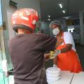 mulher entrega refeição a homem de capacete #paratodosverem 