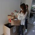 Mulheres colocam doação em caixa de papelão no posto de vacinação #paratodosverem