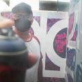 imagem mostra grafiteiro acionando spray de  perto #paratodosverem 