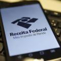smartphone aberto sobre teclado de computador. #paratodosverem