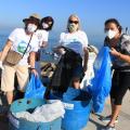 Mulheres na praia com sacos de lixo #paratodosverem