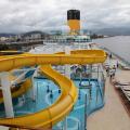 vista geral do navio com tobogã para piscina em primeiro plano. #paratodosverem