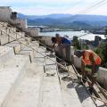 homens finalizam construção de escadaria no alto de um morro. #paratodosverem