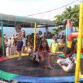 crianças brincam em pula-pula cercado por rede. #paratodosverem