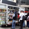 Rapaz lê livro em display no leia santos #paratodosverem 