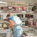 mulher pega livro em estande do projeto #paratodosverem