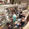 pessoas olhando o estande com livros #paratodosverem 