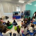 crianças estão sentadas em sala assistindo a um teatro de fantoches. #paratodosverem 