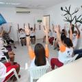 pessoas sentadas levantam a mão em sala #paratodosverem