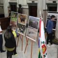 pessoas estão observando fotos em exposição. #paratodosverem
