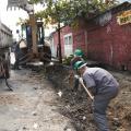 homens trabalhando em construção de sarjeta ao lado deum caminhão. #paratodosverem