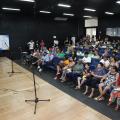 Mulheres assistem palestra em auditório. #pratodosverem