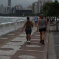 calçada da orla com muretas à esquerda e pessoas caminhando. #paratodosverem