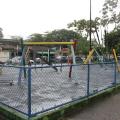 play ground com cerca e vegetação ao fundo. #paratodosverem