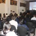 várias pessoas sentadas em auditório assistindo a uma palestra. Ao fundo há um telão onde se lê Rodada da cidadania