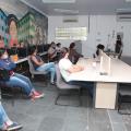 Várias pessoas sentadas em sala de aula assistindo palestra. #paratodosverem