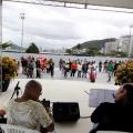 músicos tocam em palco e público está ao fundo. #paratodosverem