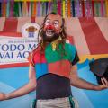 palhaço lixolino está sorrindo, com os braços abertos e segurando um chapéu na mão esquerda. #paratodosverem