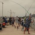 várias pessoas com varas apoiadas em deck. #paratodosverem