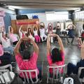 mulheres fazem alongamento sob tenda. #paratodosverem