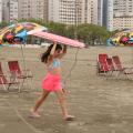 Menina caminha com prancha na faixa de areia. #pratodosverem