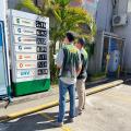 fiscais do procon observam placa com preços de combustíveis. #paratodosverem