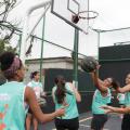 Meninas jogam basquete na quadra reformada. #pracegover