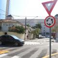 carro passa por rotatória com placa indicativa em primeiro plano #paratodosverem