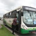 ônibus parada em via com pessoa subindo pela porta da frente. #paratodosverem