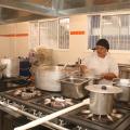 cozinha industrial com mulher trabalhando. #paratodosverem 