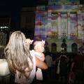 mulher com bebê assiste a projeção mapeada #paratodosverem