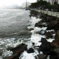mar batendo nas pedras atrás da mureta da ponta da praia. #paratodosverem