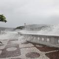 Ondas batendo em mureta da Ponta da Praia e água invadindo o calçadão. #paratodosverem